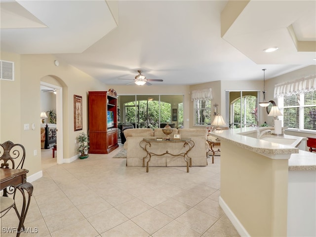 living room featuring sink, light tile patterned floors, and ceiling fan