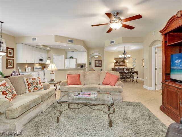 living room featuring ceiling fan with notable chandelier and light tile patterned floors