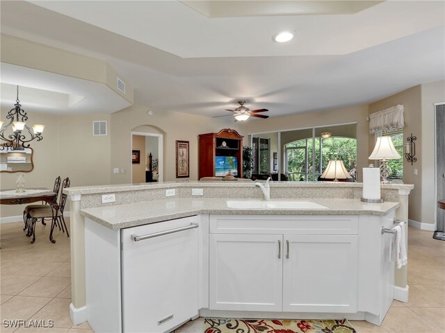 kitchen featuring light tile patterned flooring, light stone countertops, sink, white cabinets, and ceiling fan with notable chandelier