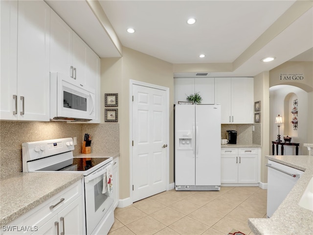 kitchen with white appliances, light stone countertops, light tile patterned floors, decorative backsplash, and white cabinets