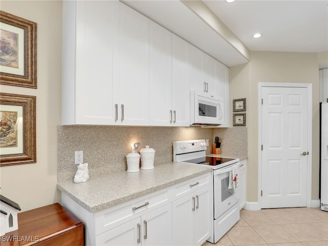 kitchen featuring white cabinets, tasteful backsplash, light tile patterned floors, and white appliances