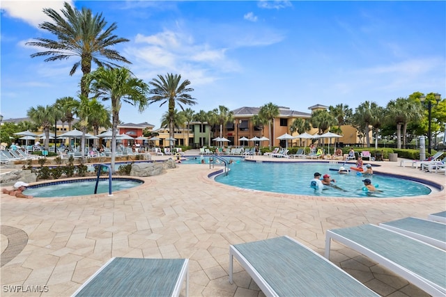 view of pool with a hot tub and a patio