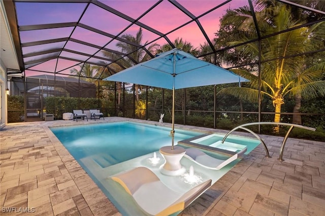 pool at dusk with a patio area and a lanai