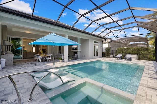 view of pool with a lanai, a patio area, and an in ground hot tub