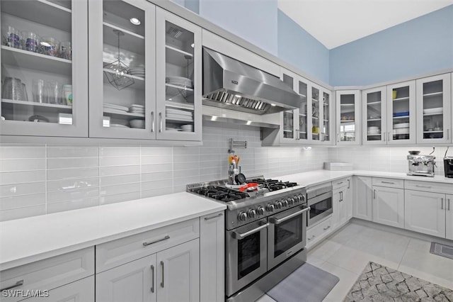 kitchen with backsplash, white cabinetry, stainless steel appliances, and exhaust hood