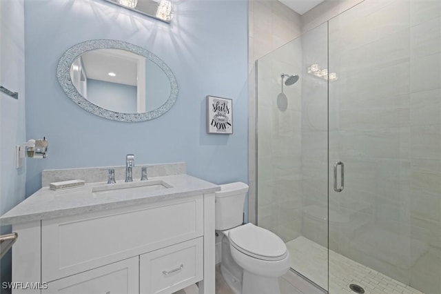 bathroom with vanity, toilet, and a shower with door