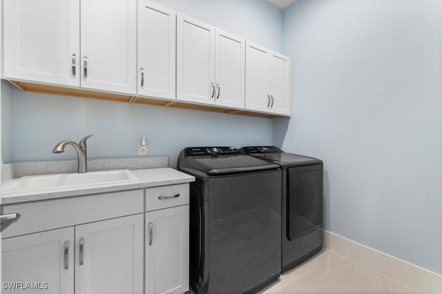 laundry area with cabinets, sink, light tile patterned floors, and washer and dryer