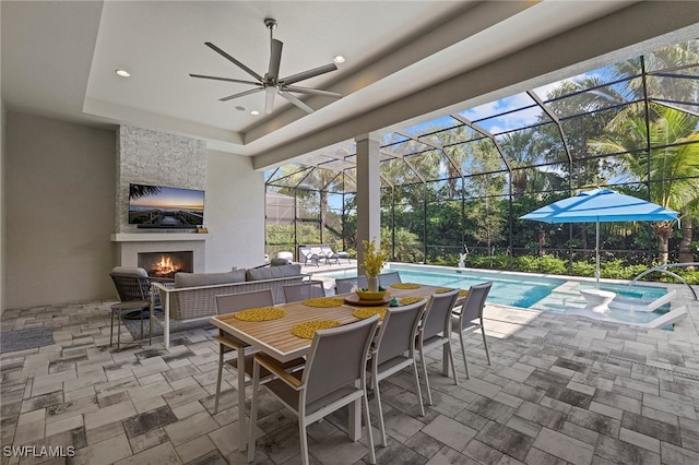 view of patio with an outdoor living space with a fireplace, glass enclosure, and ceiling fan