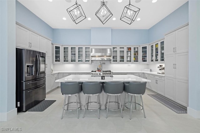 kitchen with white cabinetry, stainless steel fridge with ice dispenser, a breakfast bar, and an island with sink