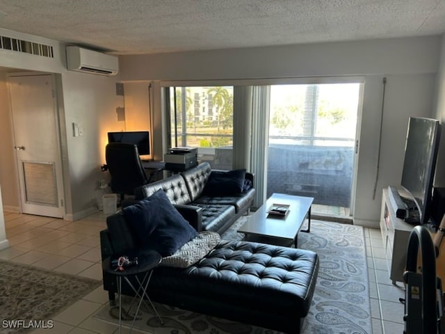 living room featuring an AC wall unit, a textured ceiling, and light tile patterned floors