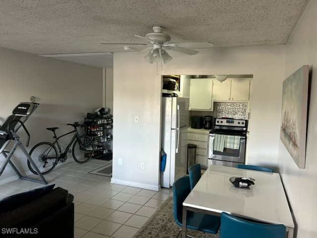 kitchen featuring stainless steel electric stove, tasteful backsplash, ceiling fan, light tile patterned flooring, and white fridge