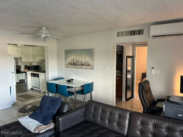 living room featuring a textured ceiling, a wall mounted AC, ceiling fan, and light tile patterned floors