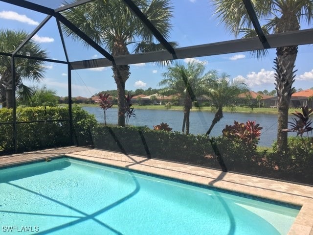 view of swimming pool featuring a water view and glass enclosure