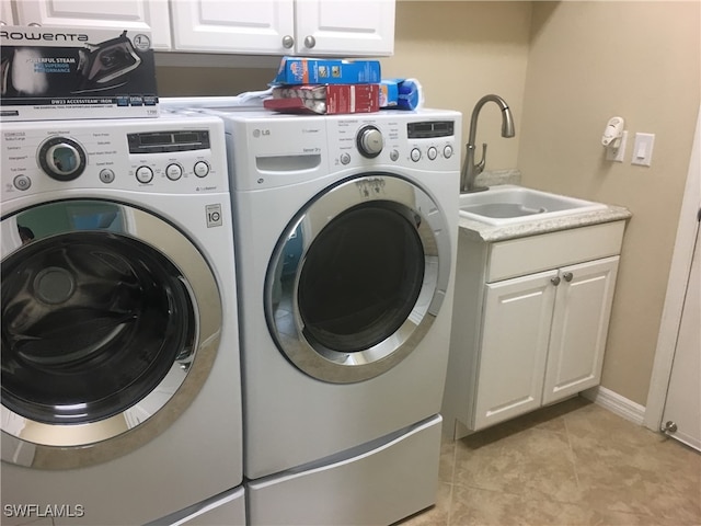 laundry room featuring cabinets, sink, washer and clothes dryer, and light tile patterned floors