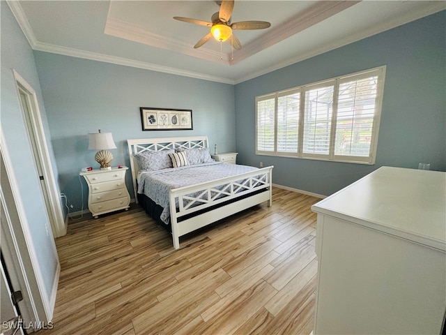 bedroom with ceiling fan, crown molding, a raised ceiling, and light wood-type flooring