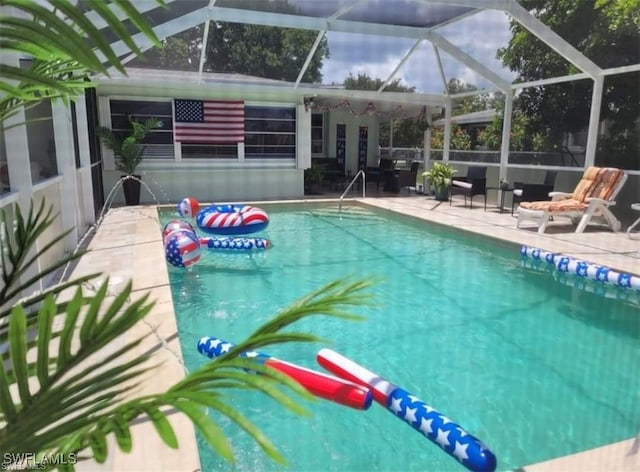 view of swimming pool featuring a patio and a lanai