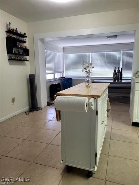 kitchen with a center island, white cabinetry, and light tile patterned floors