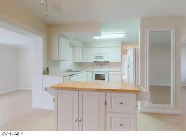 kitchen featuring white cabinets, sink, and white appliances