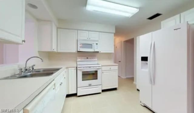 kitchen featuring sink, white cabinetry, and white appliances