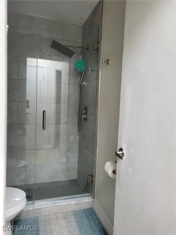 bathroom featuring toilet and an enclosed shower