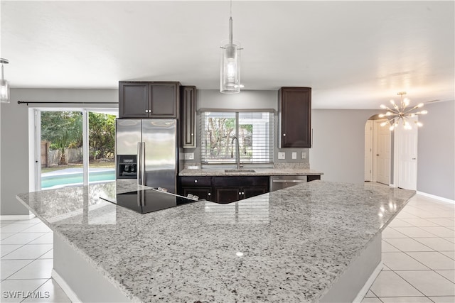 kitchen featuring pendant lighting, a kitchen island, stainless steel appliances, and light tile patterned floors