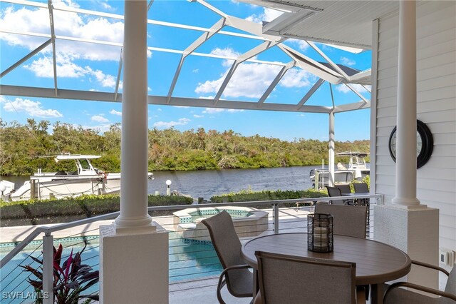 deck with a lanai, a pool with hot tub, and a water view