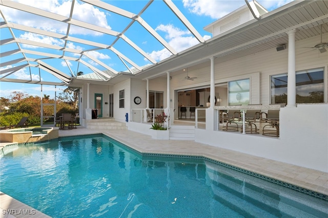 view of swimming pool with an in ground hot tub, a lanai, ceiling fan, a bar, and a patio