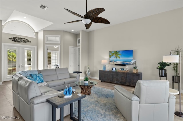 living room featuring ceiling fan, light tile patterned floors, a high ceiling, and french doors