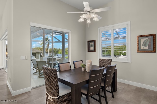 dining space with a high ceiling and ceiling fan