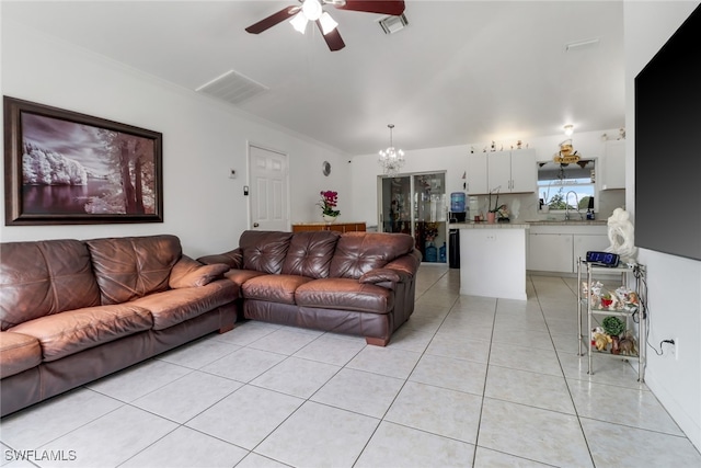 living room featuring ornamental molding, light tile patterned flooring, sink, and ceiling fan with notable chandelier