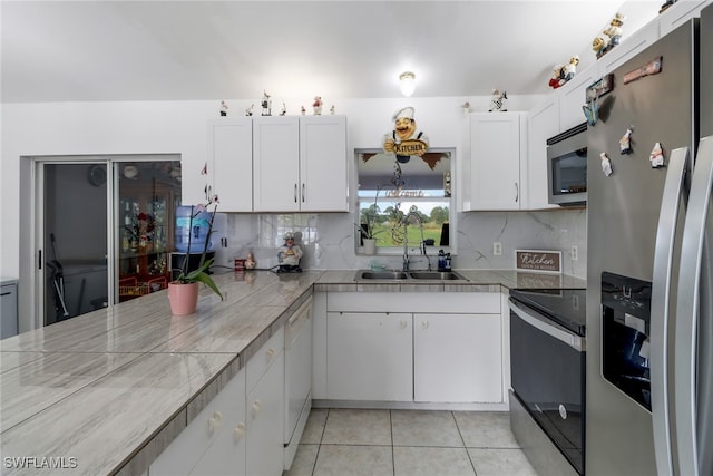 kitchen with white cabinetry, backsplash, and appliances with stainless steel finishes