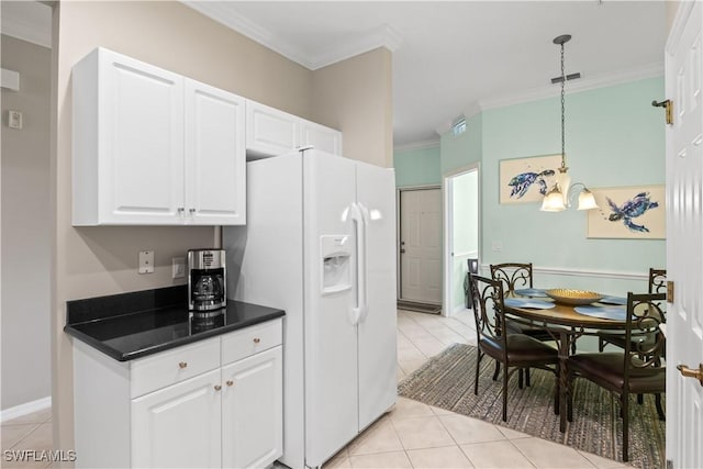 kitchen with dark countertops, white fridge with ice dispenser, white cabinets, crown molding, and light tile patterned floors