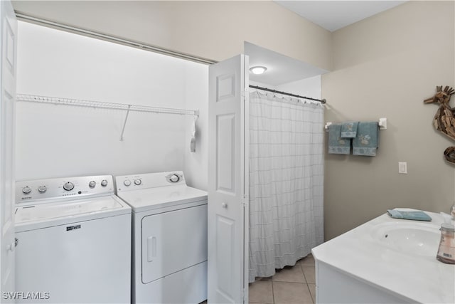 laundry room featuring sink, washing machine and dryer, and light tile patterned floors