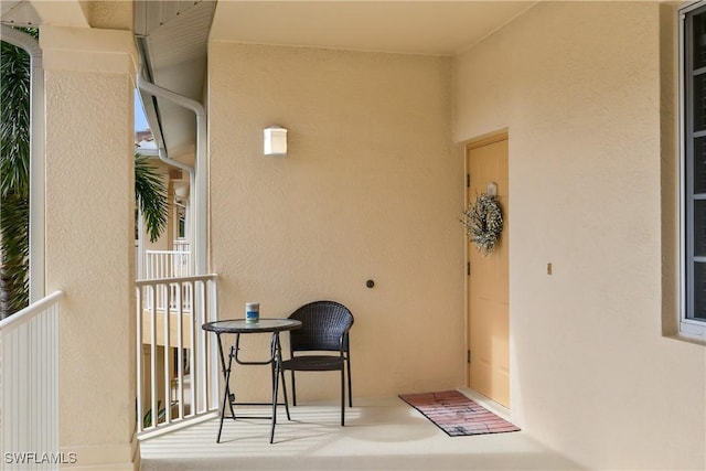 view of exterior entry featuring stucco siding and a balcony