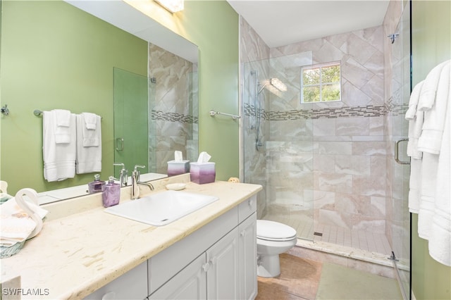 bathroom with tile patterned floors, vanity, toilet, and a shower with shower door