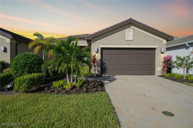 single story home with a garage and a lawn