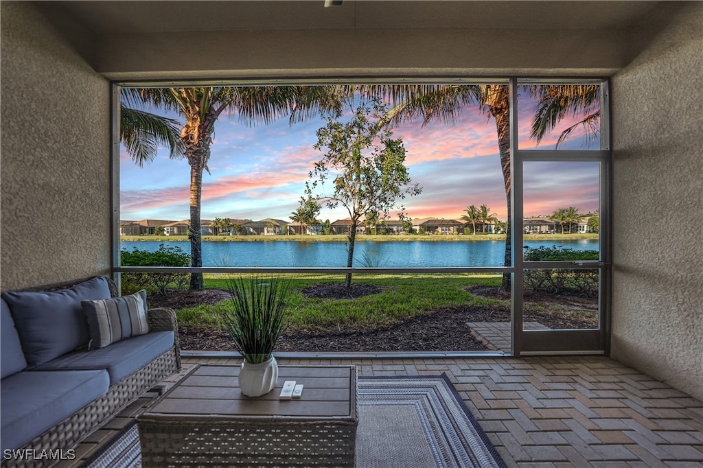 sunroom / solarium featuring a water view