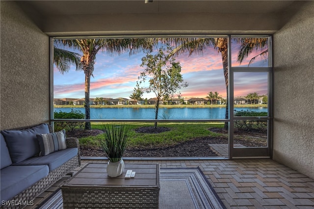 sunroom / solarium featuring a water view