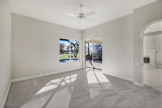 carpeted spare room featuring ceiling fan