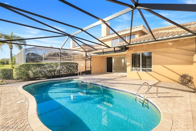 view of swimming pool with a patio and a lanai