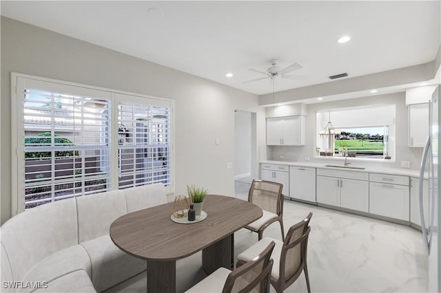 dining room with ceiling fan and sink