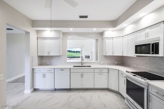 kitchen with backsplash, white cabinetry, white appliances, and sink