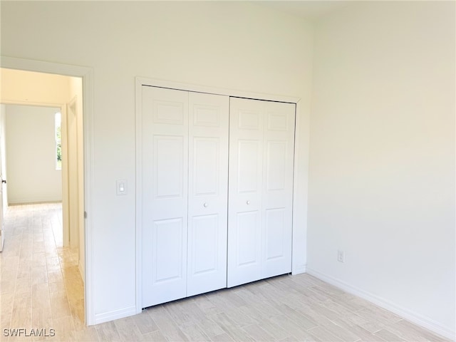 unfurnished bedroom with a closet and light hardwood / wood-style flooring