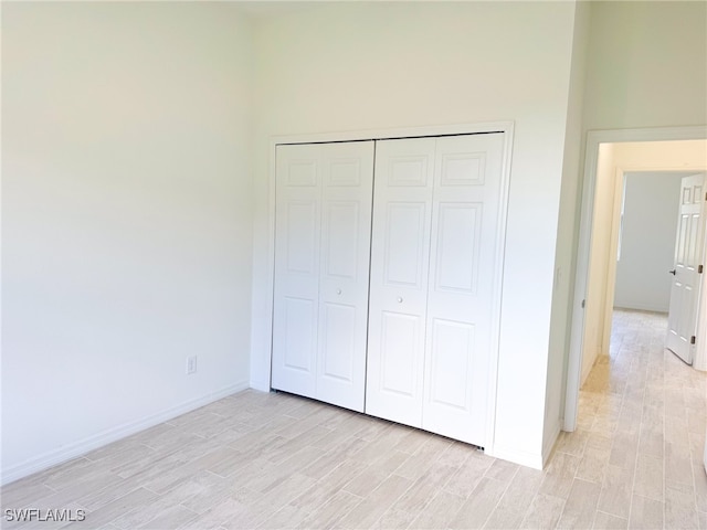 unfurnished bedroom with light hardwood / wood-style flooring and a closet