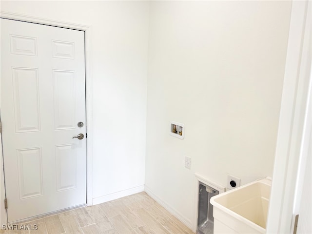 washroom with hookup for an electric dryer, light wood-type flooring, and hookup for a washing machine