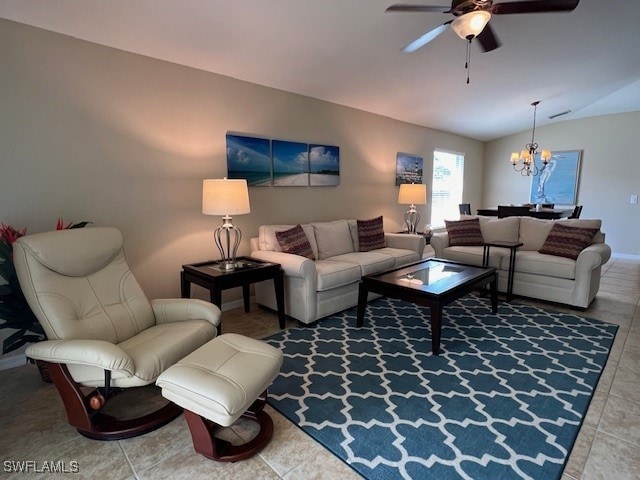 living room with tile patterned flooring, ceiling fan with notable chandelier, and lofted ceiling