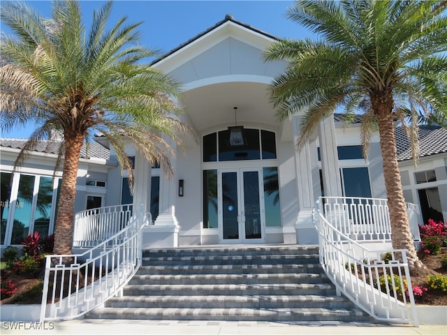 property entrance featuring covered porch and french doors