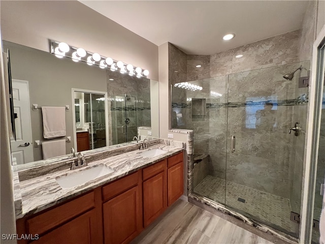 bathroom featuring hardwood / wood-style floors, vanity, and a shower with door