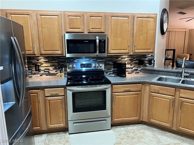 kitchen featuring decorative backsplash, appliances with stainless steel finishes, ceiling fan, and sink