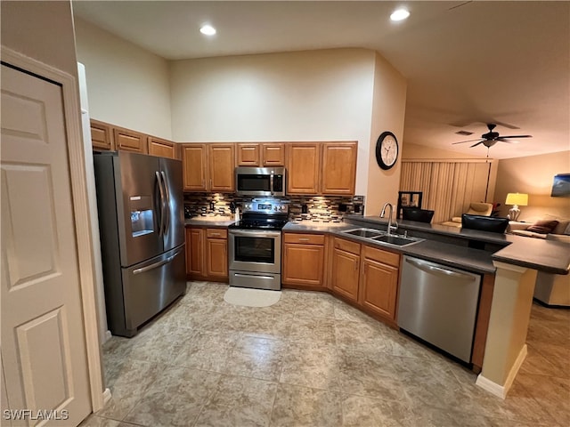 kitchen featuring sink, ceiling fan, decorative backsplash, kitchen peninsula, and stainless steel appliances